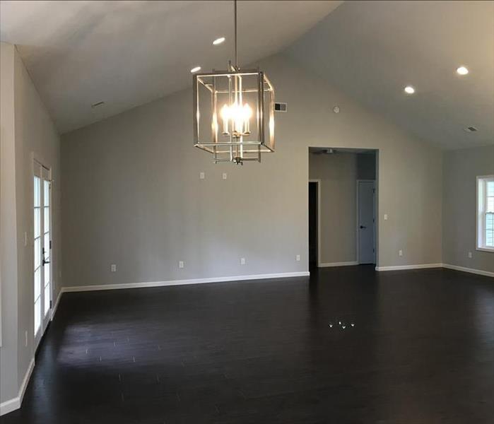 Clean and empty living room with hard wood flooring and new hanging lantern