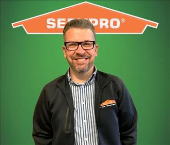 New employee standing in front of a SERVPRO backgound